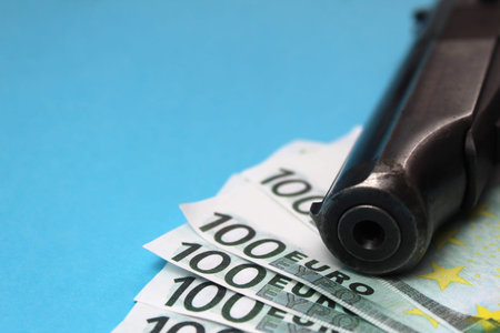 He barrel of a gun lie on banknotes