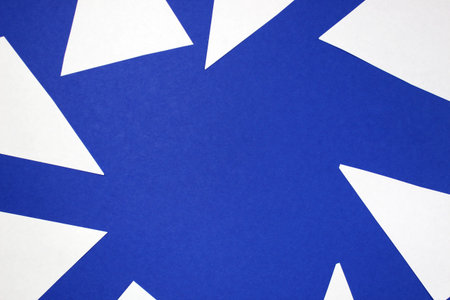 Small white paper sheets with sharp corners lie on a blue background