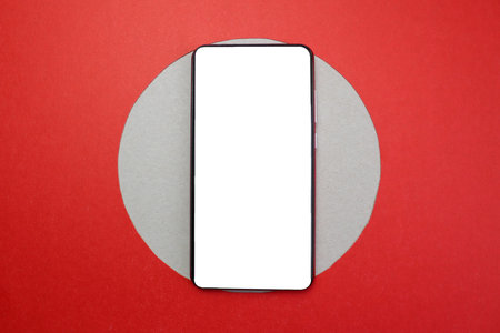 The phone lies on a red background in a circle