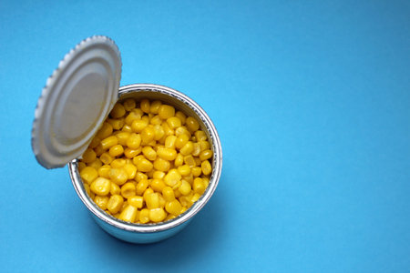 Jar with canned yellow corn on a blue background