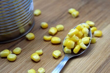 Jar of canned corn with a spoon on the tableの写真素材
