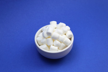 White little marshmallows lies in a white plate