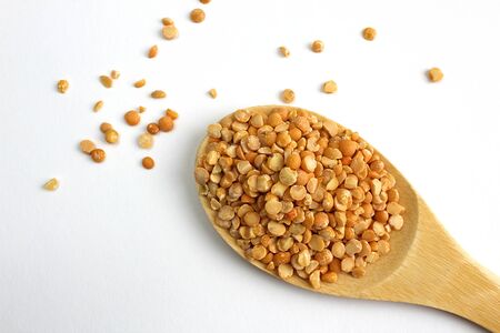 Wooden spoon with small peas on a white backgroundの写真素材