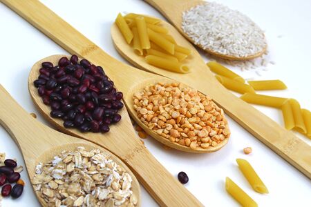 On wooden spoons are ingredients for garnishes on a white backgroundの写真素材