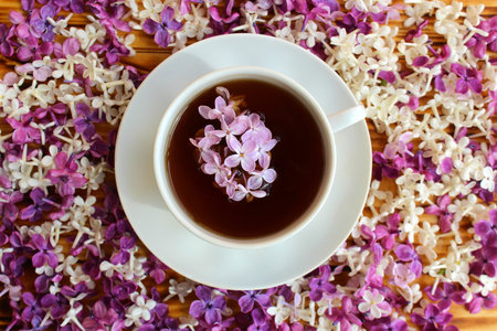Cup of tea on a background of a wooden table and spring lilacの写真素材