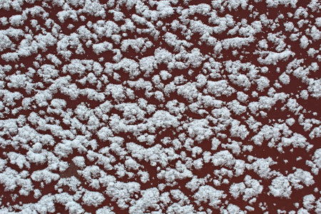 White snow lies on an iron painted surfaceの写真素材