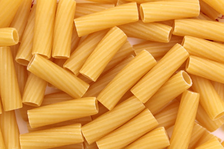 Texture of golden brown pasta in the form of pipesの写真素材