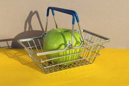 Green apple lies in the grocery basket