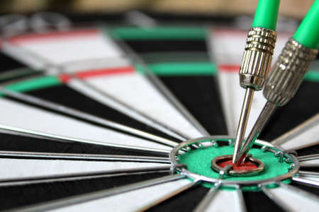 Two darts stuck in the center of the targetの写真素材