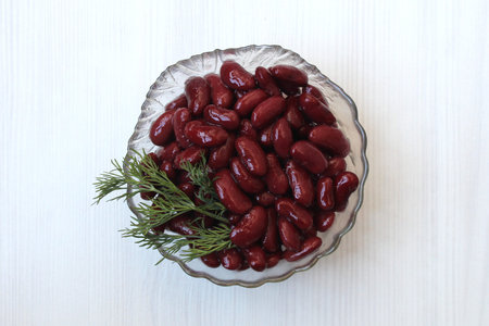 Canned red beans lie on a transparent plate