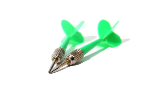Green dart darts lie on white background with place for text
