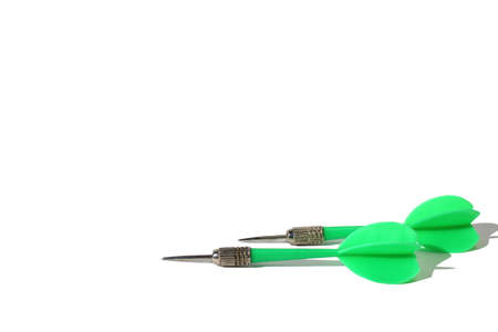 Green dart darts lie on white background with place for textの写真素材