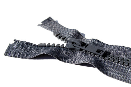 Gray zipper for clothes lies on a white background