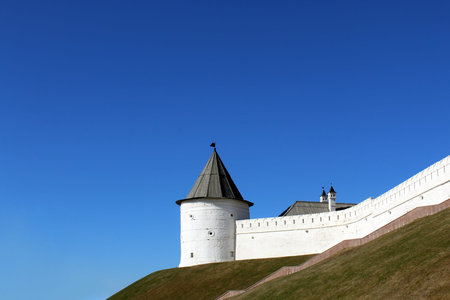White tower of the kremlin with a wooden roof against the backdrop of a clear sky