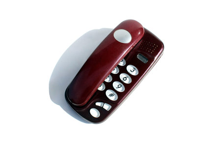 Burgundy landline phone stands on a white background