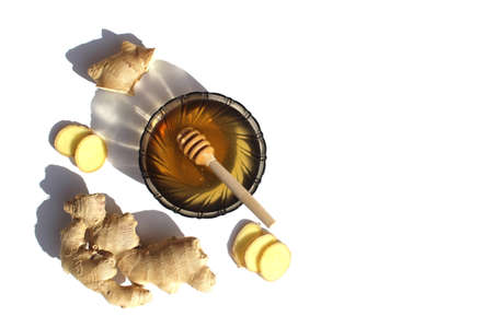 At sunset, a man walks into the sea for a swim. Ginger and lemon stand on a white background. Cold remedies.の写真素材