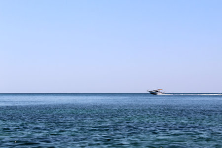 In the distance, a yacht rushes along the sea at high speedの写真素材