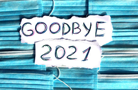 On the medical masks there is paper with the inscription Goodbye 2021.の写真素材