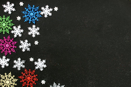 Christmas background with snowflakes of different sizes on a black background with place for text.の写真素材