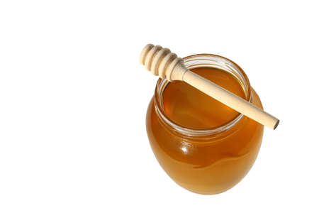 Fresh liquid honey in jar on white isolated backgroundの写真素材