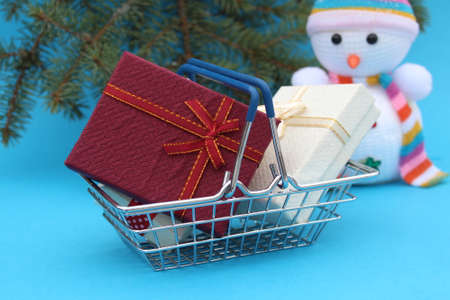 For Christmas, gift boxes are in a decorative basket.の写真素材