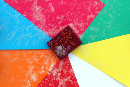 Abstract bright colorful background under the snow and with a gift box.の写真素材