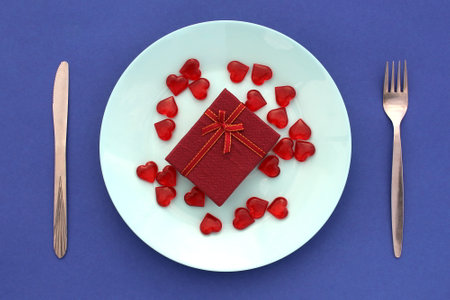 There are many small valentines and a gift box on the plate.の写真素材