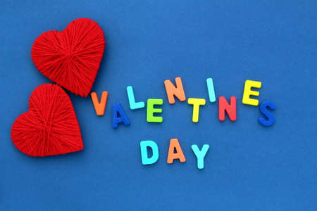On a blue background, there are two hearts and the inscription `Valentine`s Day`.の写真素材