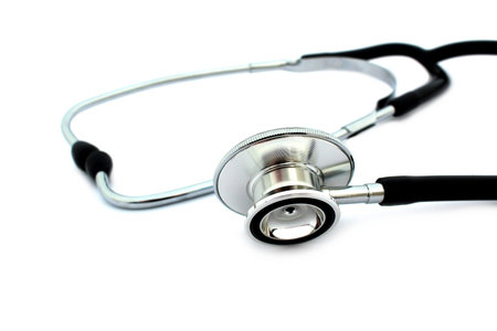 On a white isolated background lies a black stethoscope.の写真素材
