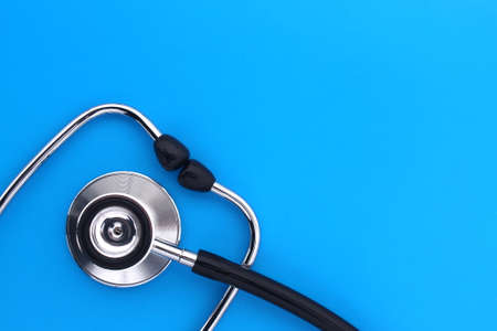 The stethoscope lies on a blue bright background.の写真素材