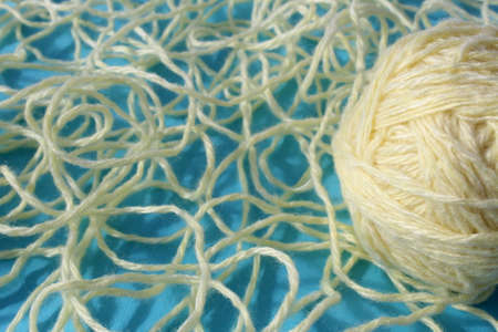 Threads of beige color with a ball lie on a blue background.の写真素材