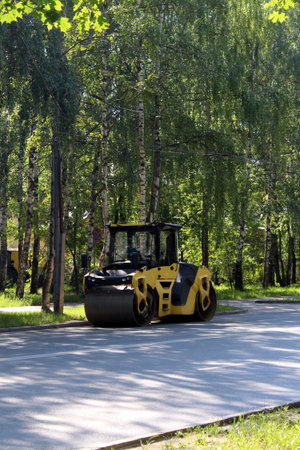 There is an asphalt paver on the edge of the road.
