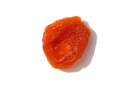 One dried apricot lies on a white background.の写真素材