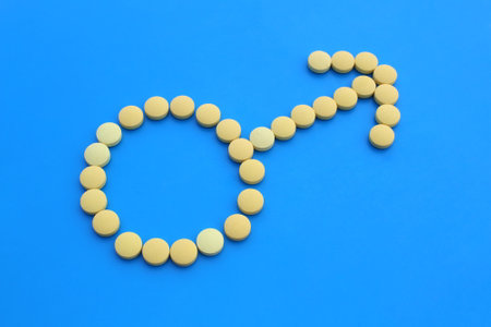 Male sign with yellow pills on a blue background.の写真素材