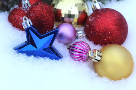 Bright Christmas toys lie on the snow.の写真素材