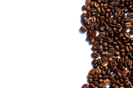 Coffee beans are scattered over a white isolated background.の写真素材