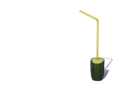 On a white isolated background, there is half a cucumber with a straw for a cocktail.の写真素材