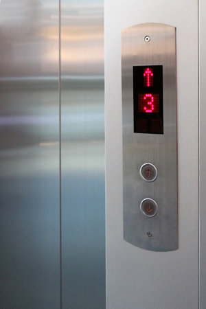 The elevator button and number screen show the floor and direction.の写真素材