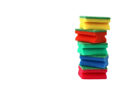 Many bright multi-colored sponges for washing dishes lie on a white background.の写真素材