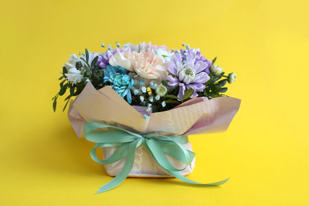On a yellow background is a bouquet of beautiful flowers.の写真素材