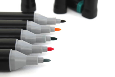 A set of bright colorful open markers lies on a white background.の写真素材