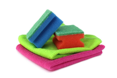 On a white background lie sponges and rags of bright different colors for cleaning housing.の写真素材