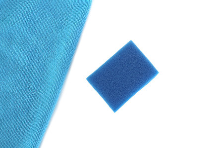 On a white background lies a blue rag and a sponge for cleaning.の写真素材