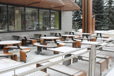 The tables at the cafe on the street are covered with snow in winter.の写真素材