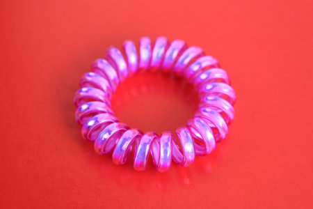 A bright hair band lies on a red background.の写真素材