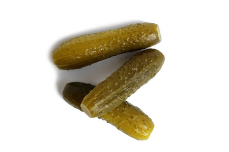 Three pickled cucumbers lie on a white background.の写真素材