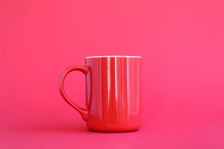 There is a red porcelain mug on a red background.の写真素材