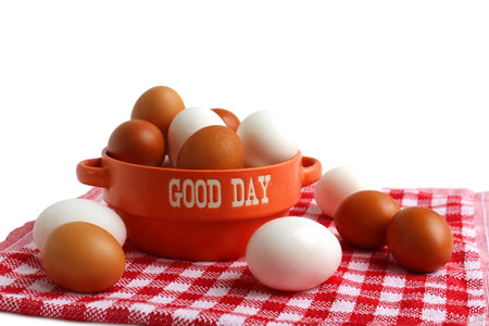 There are many chicken eggs in a plate on a table with a tablecloth.の写真素材