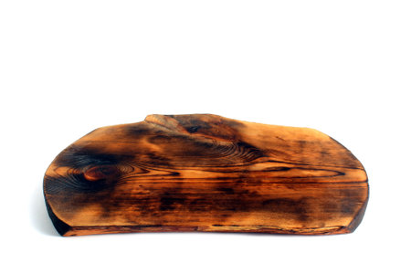 A wooden cutting board of an unusual shape lies on a white background.の写真素材