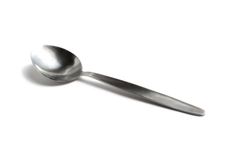 Iron gray spoon lies on a white isolated background.の写真素材